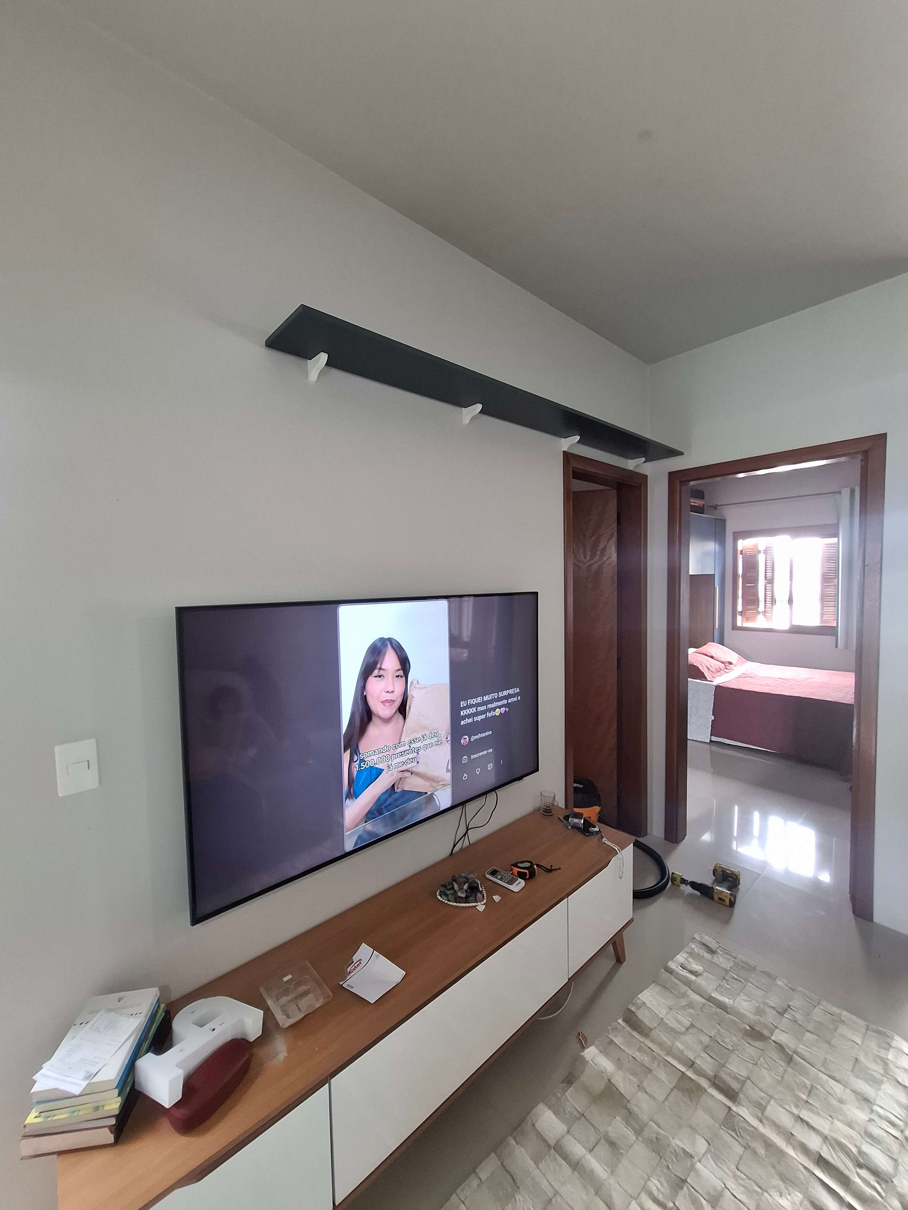 Instalação de prateleira preta e suporte de TV